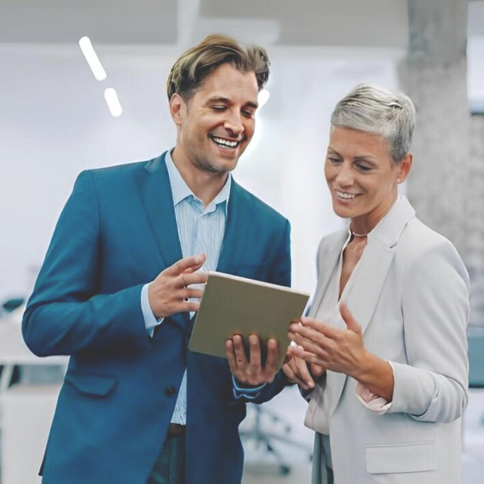 Two executives are looking at the iPad and discussing work.