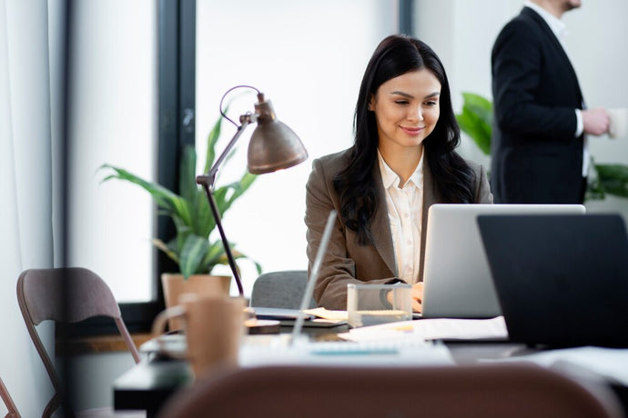A woman is working with laptop in her office.