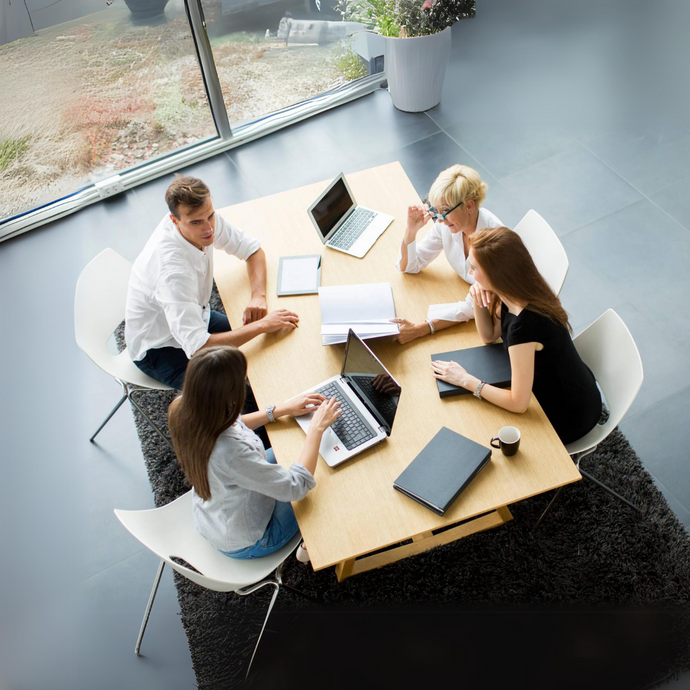 Four executives discussing a project around a conference table.
