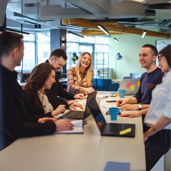 Members of two teams happily engaged in a project scoping session in a meeting room.