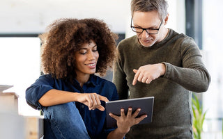 Business team reviewing ERP reports and business performance on a tablet.