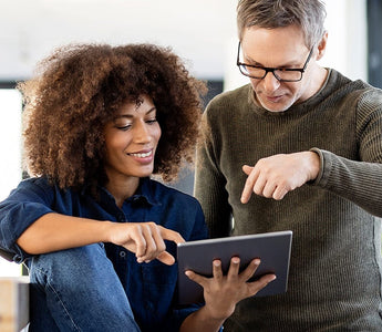 Business team reviewing ERP reports and business performance on a tablet.