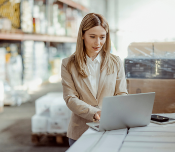 Warehouse manager checking warehouse data on a computer.