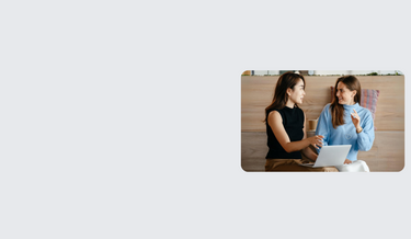 Female employee holding a laptop, explaining a solution to a client.