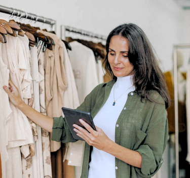 clothing owner using tablet to check stock levels.