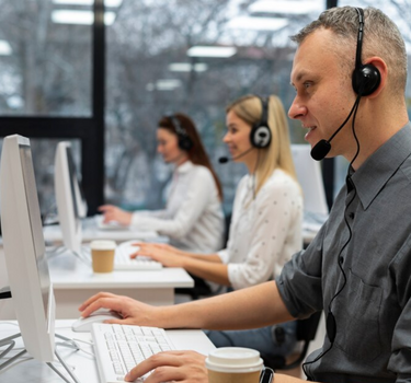 Support department employees are wearing a headset and answering phones to resolve customer issues.